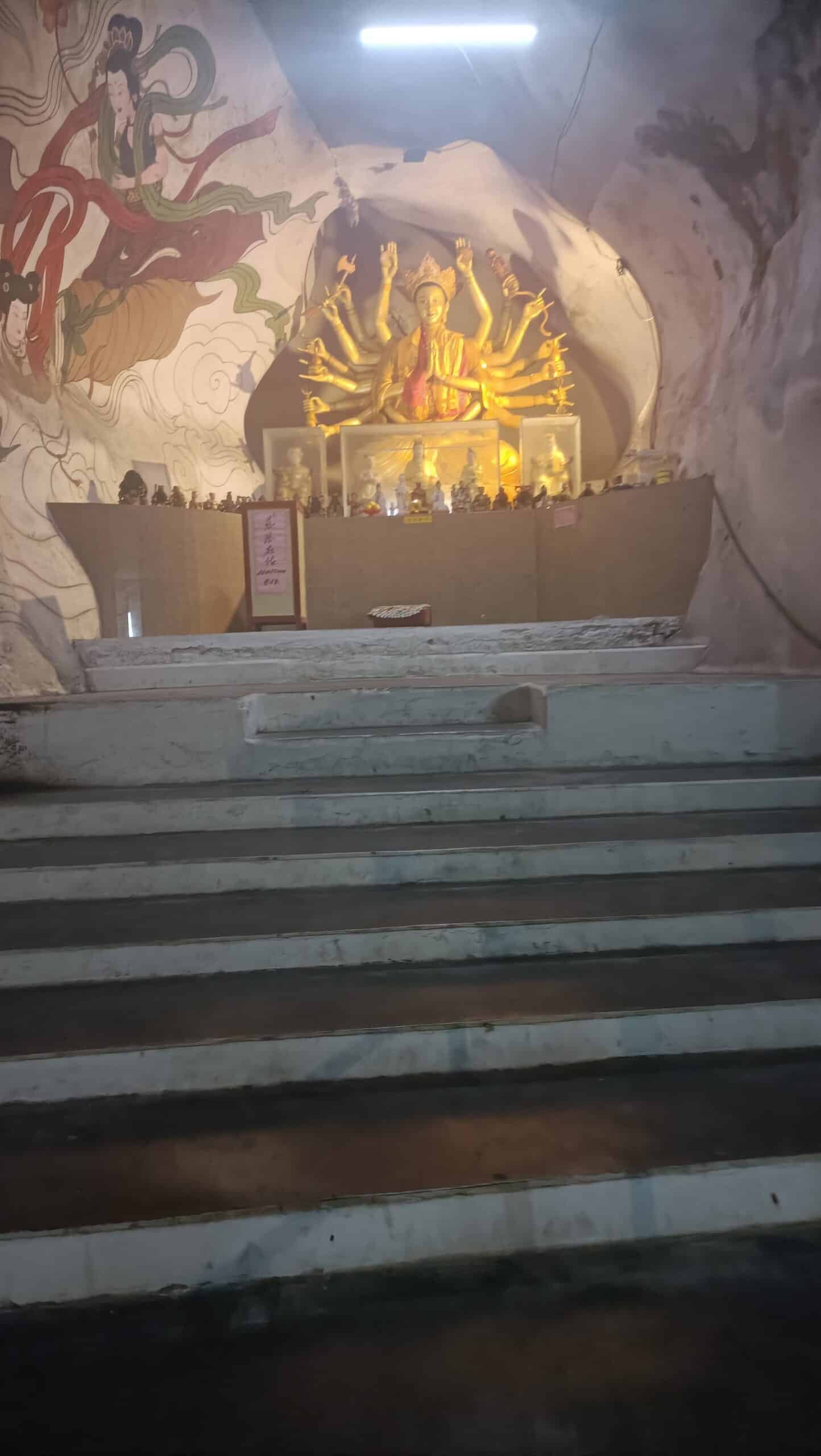Golden thousand-handed Guan Yin statue on an altar inside Perak Tong Cave Temple in Ipoh