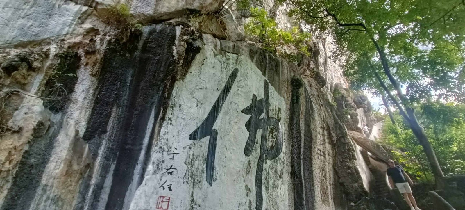 Large Chinese calligraphy characters painted on a limestone cliff at Perak Tong Cave Temple in Ipoh