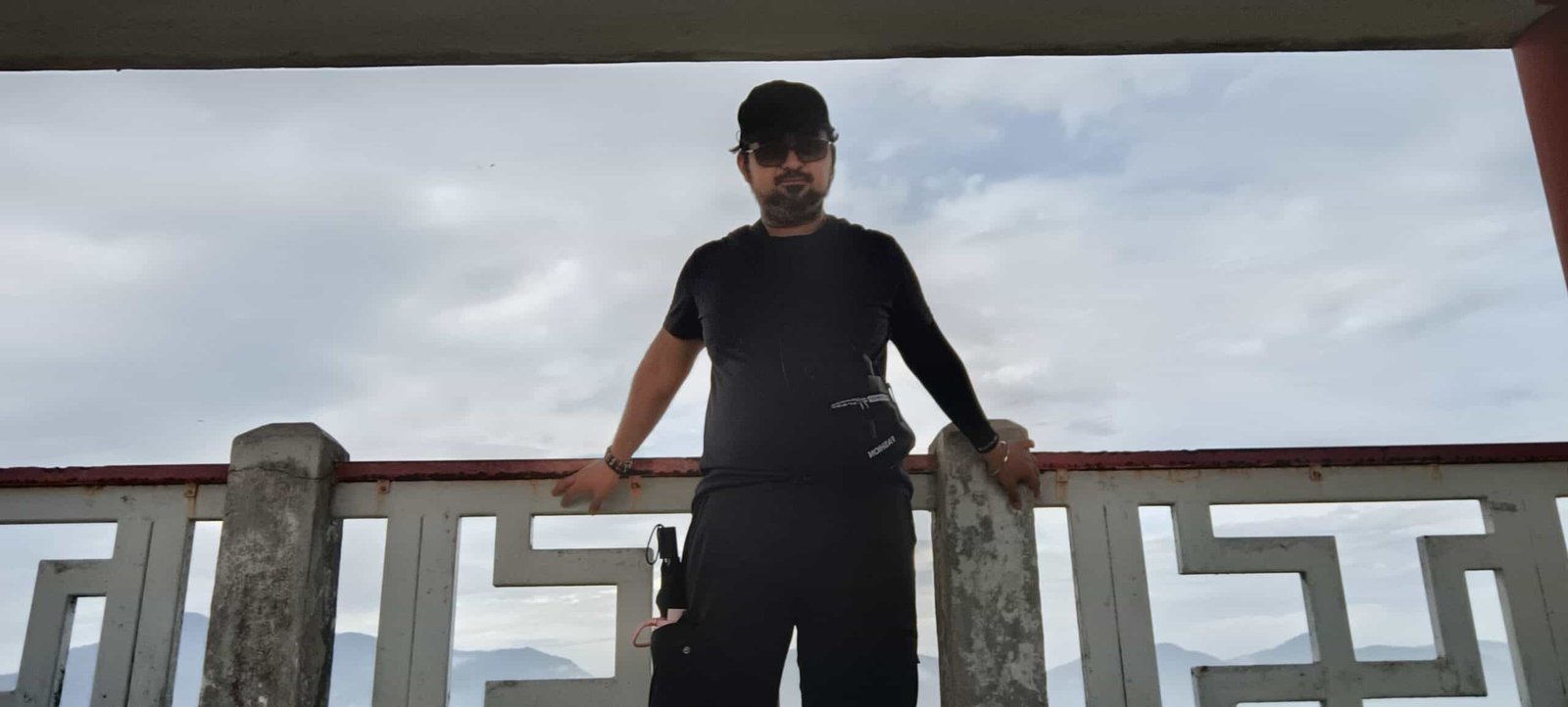 MK standing by railing with panoramic Ipoh city view behind at Perak Tong Cave Temple peak